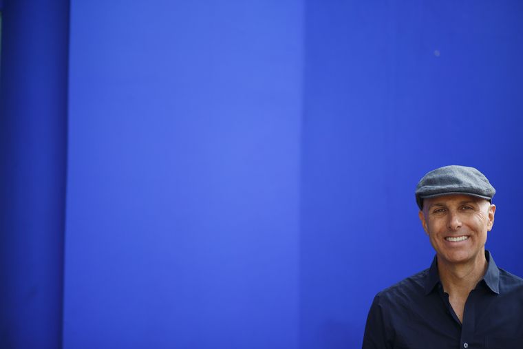 Portrait in a flat cap against a deep blue wall, YSL Gardens, Marrakech